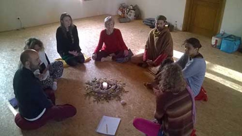 Groupe de personnes assis en rond autour d'une bougie